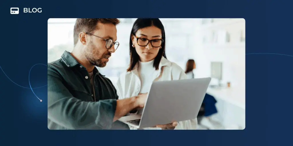 Two people wearing glasses look at a laptop screen together in a bright office setting, discussing customer success strategies. The image is framed on a blue background with the word "BLOG" in the corner.