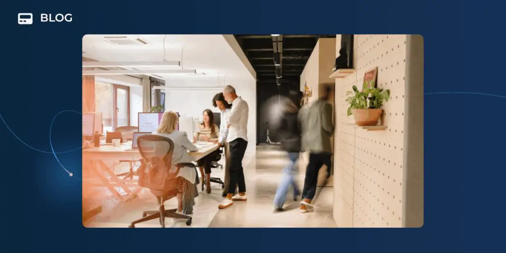 Modern office scene with several people working and discussing revenue growth around desks, while two people walk past in a blur. Bright, open workspace with large windows and plants, set against a dark blue blog template background.