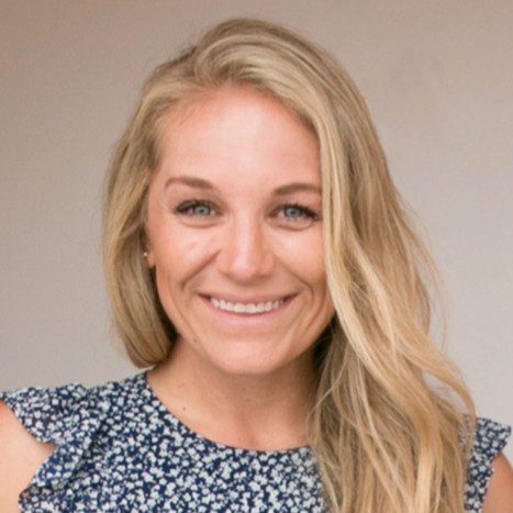 A woman with long blonde hair and a floral patterned top smiles while looking at the camera, embodying confidence—perfect for illustrating How To Stop Managing 38% of Your Customers in 2026. The background is plain and neutral.
