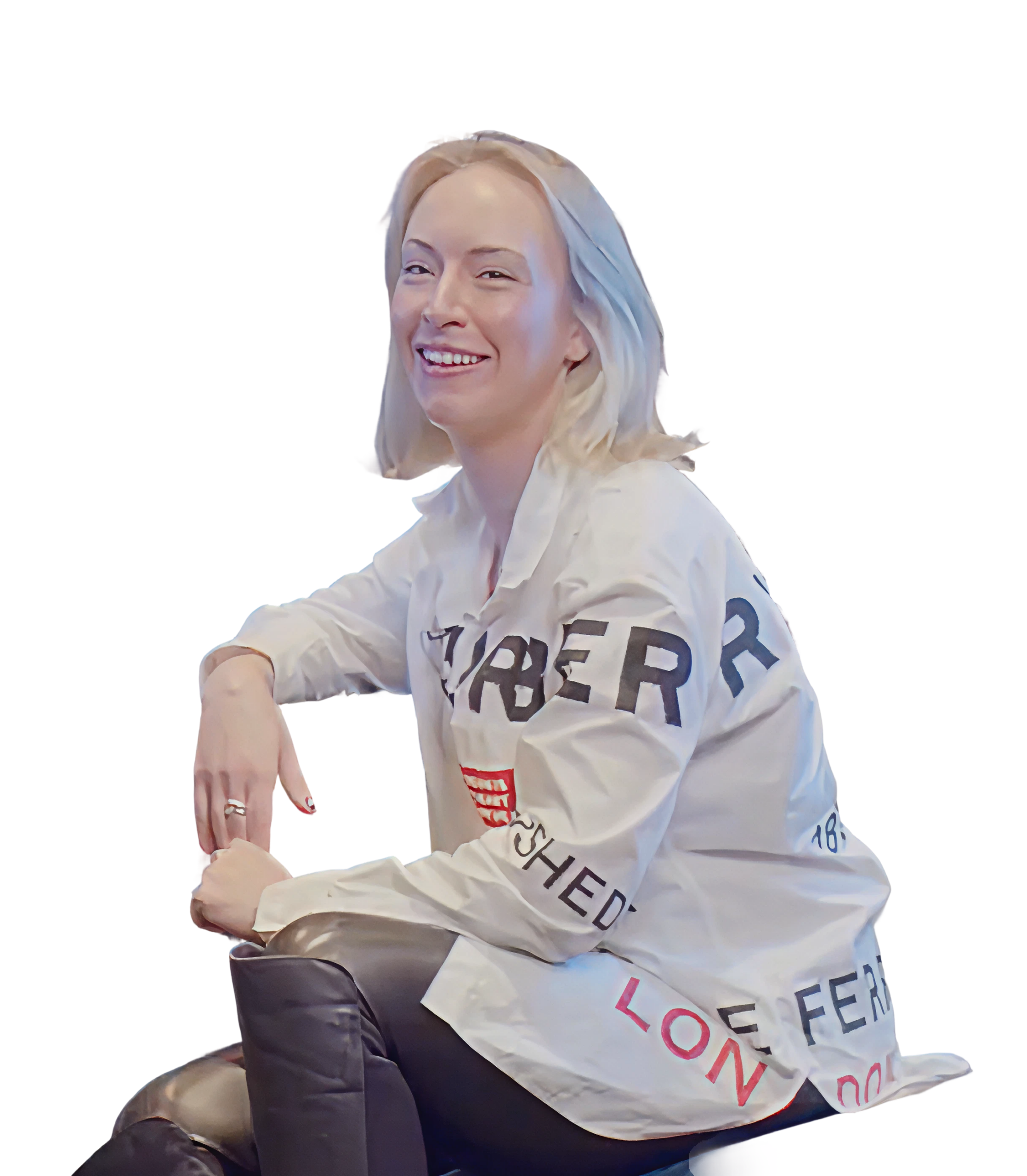 A woman with blonde hair sits smiling, wearing a white button-up shirt with bold black and red text referencing Supermetrics, and black leather pants, against a plain white background.