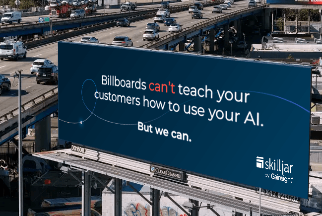 A large digital billboard above a busy highway reads, "Billboards can't teach your customers how to use your AI. But we can with Customer Education." The bottom right corner shows the Skilljar by Gainsight logo.