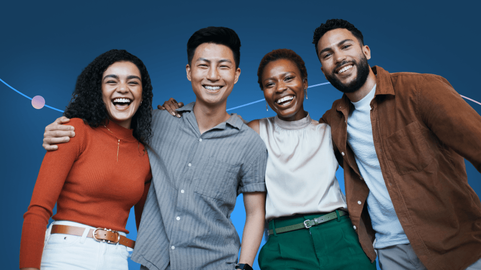 Four people stand closely together, smiling and posing against a blue background with curved lines. They appear happy and diverse, reflecting positive outcomes of effective onboarding while wearing casual outfits in warm and neutral colors.