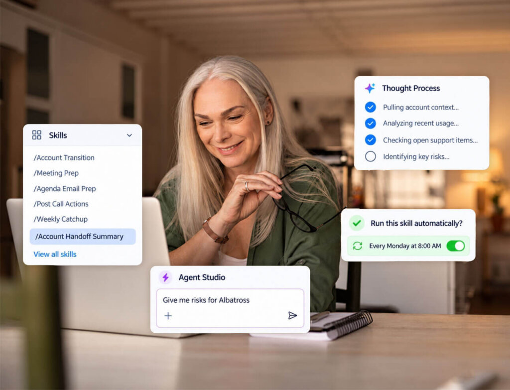 A woman with long gray hair smiles at a laptop. Floating digital menus show skills, processes, toggles, and chat prompts, illustrating workplace productivity tools. The background is a bright, homey workspace.