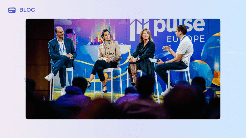 Four panelists sit on tall stools on a stage in front of a “Pulse Europe” backdrop, participating in a discussion at a business event.