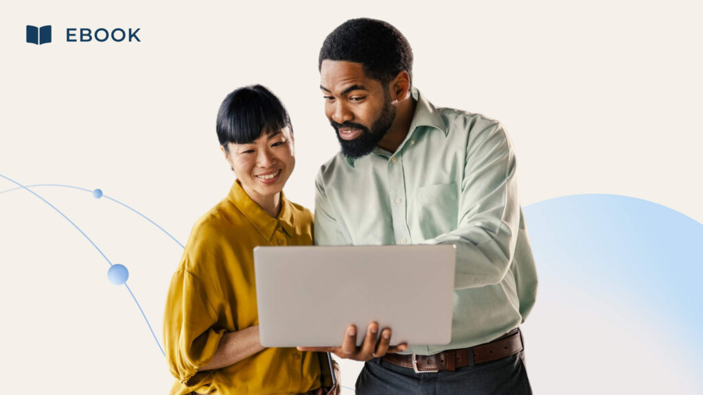 A man and woman smile while looking at an eBook on a laptop, collaborating to define value together.
